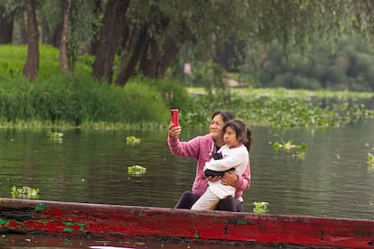 Una madre e hija esperan la pasada de la reliquia de San Judas sobre una balsa en Xochimilco. 