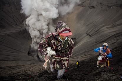 Un indonesio atrapa a un pollo que fue lanzado como ofrenda al cráter del Monte Bromo con motivo de la celebración del Festival Kasada, en Probolinggo, Java Oriental, Indonesia.