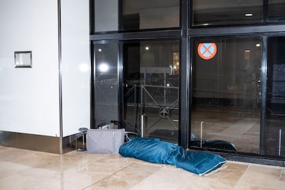 Una persona duerme en los pasillos que conectan la terminal 1 y 2 de Barajas durante la madrugada del lunes. 