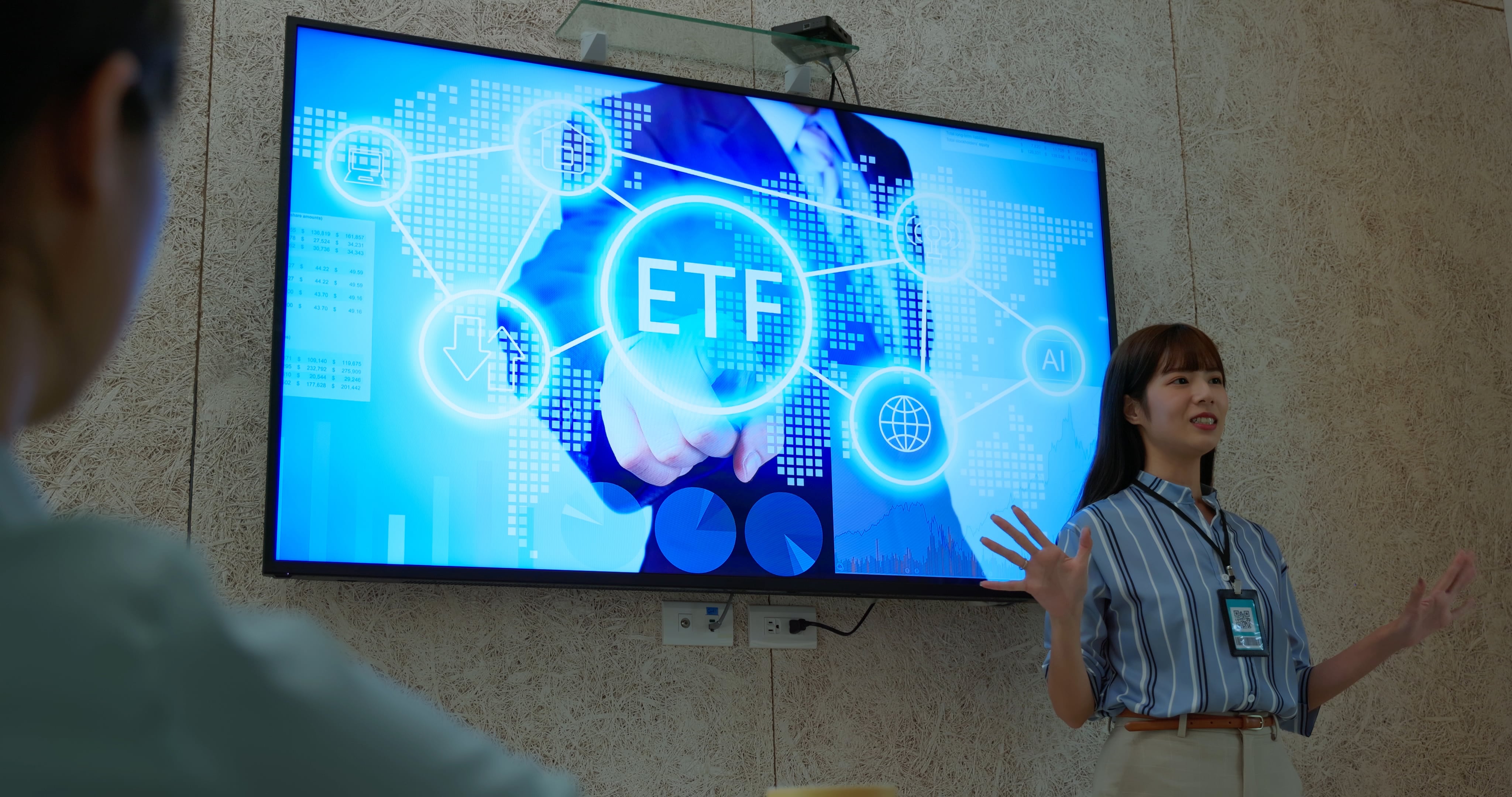 Una empresaria asiática especialista en finanzas presenta un ETF en una sala de reuniones.