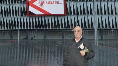 Eduardo Rodrigálvarez posa con uno de sus libros delante del estadio de San Mamés.