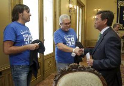 El presidente de la Diputación de Burgos, Cesar Rico (d), saluda a unos miembros del comité de empresa de Nuclenor tras la reunión que han mantenido hoy en la sede de la institución regional.