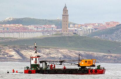 Una gabarra prepara la voladura de las primeras rocas submarinas donde encalló el <i>Urquiola.</i>