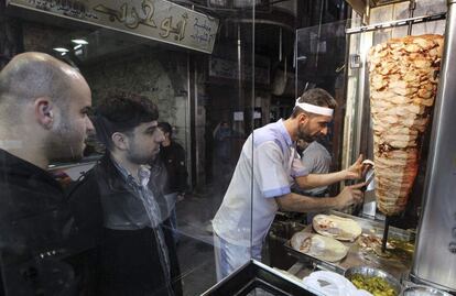 Un par de clientes esperan a que les preparen un 'shawarma' el pasado noviembre en el centro de la capital siria.