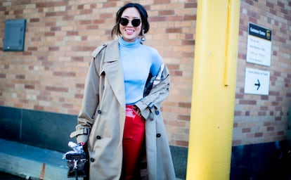 Pendiente grande (solo en una oreja), pantalones de vinilo y gabardina descolocada: así se mezclan las reglas del momento en un mismo look.