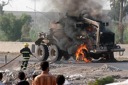 Un bombero iraqu trata de sofocar el incendio en un camin militar de EE UU tras sufrir un atentado ayer en Bagdad.