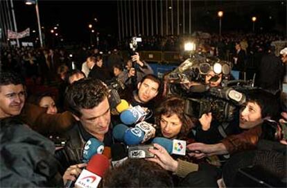 Julio Medem, a su llegada a la gala de los Goya. Al fondo, los manifestantes convocados por la Asociación Víctimas del Terrorismo.