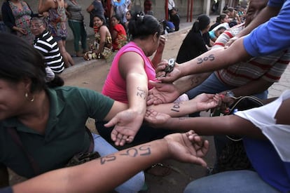 Los que esperan apuntan su número de la fila en los brazos. La imagen es de una cola en las puertas de Bicentenario en Maracaibo.