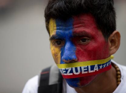 Un hombre se tapa la boca con una cinta con los colores de la bandera de Venezuela para protestar por la irrupci&oacute;n de los funcionarios en los campamentos que se hab&iacute;an levantado en la calle durante las protestas estudiantiles. La polic&iacute;a ha desmantelado las carpas que los estudiantes hab&iacute;an colocado en la calle y ha detenido a m&aacute;s de 200 personas. 