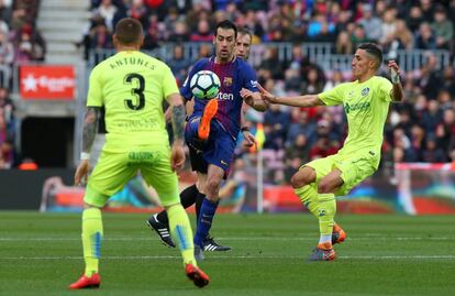 Sergio Busquets controla la pelota antel los jugadores del Getafe.