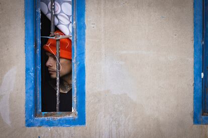 A prisoner looks out his cell window. 