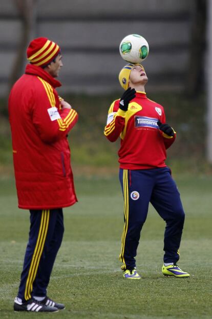 El rumano Torje, con un balón junto al seleccionador Victor Piturca en el entrenamiento en Bucarest.