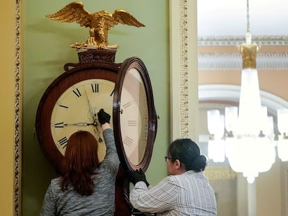 Dos trabajadoras del Capitolio ajustan un reloj, el 21 de enero de 2020.