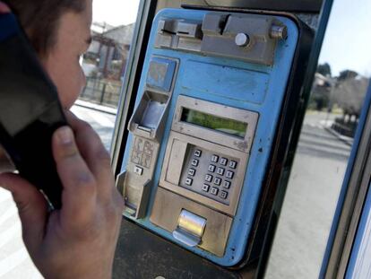 Un joven utiliza una cabina de tel&eacute;fono