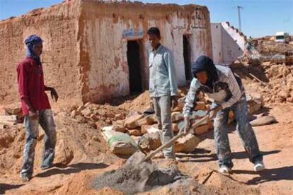 Saharauis trabajan en la reconstrucción de sus casas, arrasadas por las lluvias, en los campos de Tinduf.