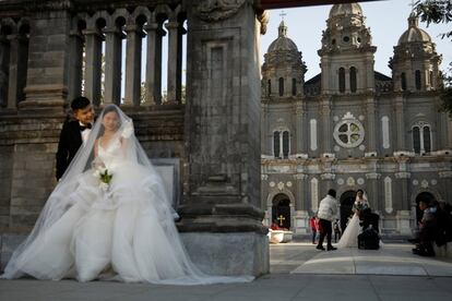 Varias parejas de novios asisten a las sesiones de fotos de su boda frente a una iglesia católica en Pekín (China). El Ministerio de Salud de China ha informado este jueves de que se han contabilizado 15 casos de coronavirus, de los cuales 14 corresponden a contagios procedentes del extranjero. El único positivo de transmisión comunitaria ha sido diagnosticado en el municipio de Tianjin, en el noreste del país.