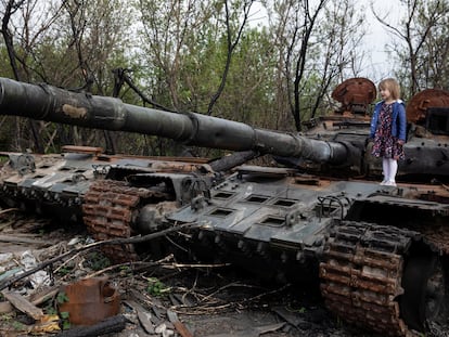 Una niña se para en un tanque ruso destruido, cerca de Kiev, el 7 de mayo.