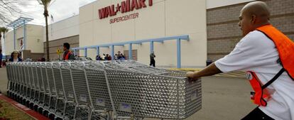 Empleados de Walmart en un establecimiento de California recogen los carros usados por los clientes. 