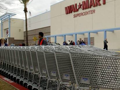 Empleados de Walmart en un establecimiento de California recogen los carros usados por los clientes. 