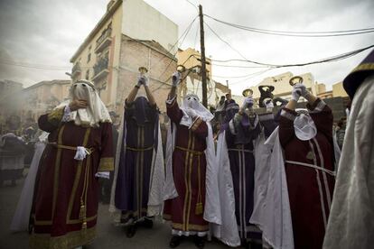 Penitentes de la Cofradía de los Gitanos anuncian con campanas la salida de la imagen del Cristo al comienzo de la procesión que ha recorrido las calles de Málaga el Lunes Santo, 25 de marzo de 2013.