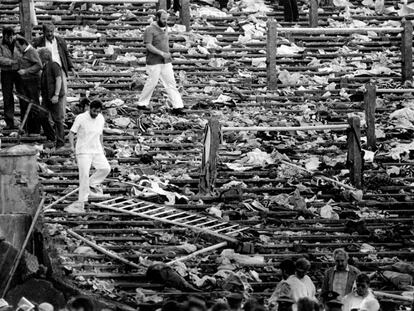 Espectadores entre los restos de la grada arrasada del estadio Heysel, en Bruselas, en 1985.