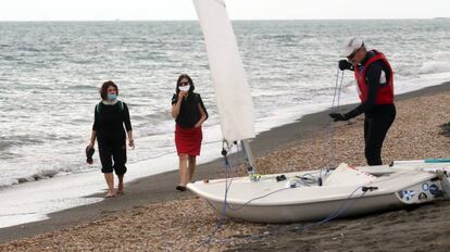 Personas con máscaras faciales caminan por la playa de Ostia, en Roma, mientras algunas restricciones comienzan a levantarse durante la pandemia de coronavirus. El 18 de mayo fue el primer día que se permitió ir a las playas de este municipio de Roma después de más de dos meses de un cierre nacional para frenar la propagación de la Covid-19. (Foto de Elisabetta A. Villa / Getty Images)