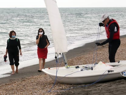 Personas con máscaras faciales caminan por la playa de Ostia, en Roma, mientras algunas restricciones comienzan a levantarse durante la pandemia de coronavirus. El 18 de mayo fue el primer día que se permitió ir a las playas de este municipio de Roma después de más de dos meses de un cierre nacional para frenar la propagación de la Covid-19. (Foto de Elisabetta A. Villa / Getty Images)
 