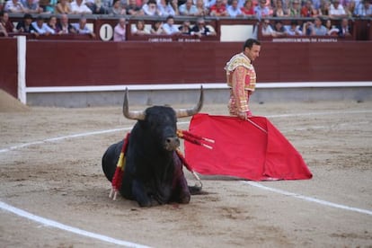 El torero Rafaelillo, ante su primer toro, echado en el suelo.