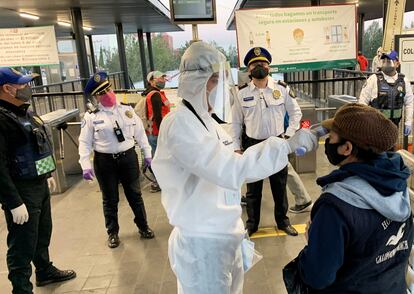 Usuarios del transporte público de Ciudad de México pasan este lunes por un filtro de seguridad.