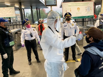 Usuarios del transporte público de Ciudad de México pasan este lunes por un filtro de seguridad.