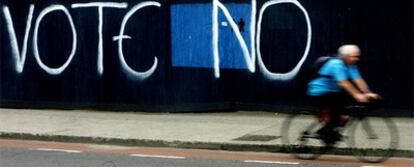Un ciclista pasa ante una pintada en una calle de Dublín que pide el n en el referéndum.
