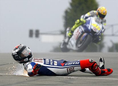 Lorenzo no ha tenido suerte en el Gran Premio de Donington Park. Cuando rodaba primero con cierta ventaja sobre Valentino Rossi se cae de la moto y tiene que retirarse. Su mono hecha chispas al deslizarse por el asfalto, mientras Rossi pasa por detrás.