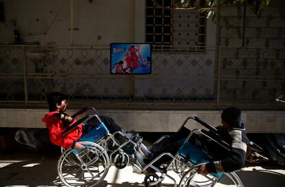 Dos pacientes, que sufren lesiones en la médula espinal, juegan con sus sillas en el centro de rehabilitación de Douma, en Damasco (Siria).