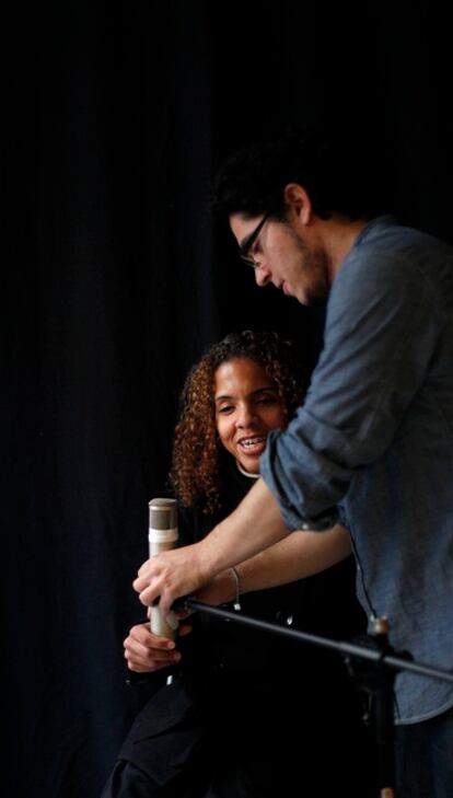 The pianist Luis Guerra adjusting the mic for Bautista ahead of a performance.