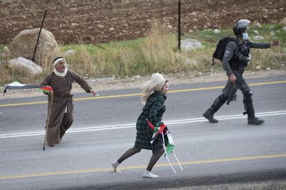 Una manifestante corre detrás de una israelí después de haber tomado las banderas palestinas tras una protesta contra el movimiento de expansión de los asentamientos judíos israelíes cerca del pueblo de Kafr Malik, cerca de la ciudad de Ramallah, en Cisjordania.