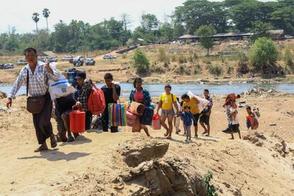 People cross the Moei river as they flee Myawaddy township in Myanmar to Thailand's Mae Sot town in Thailand's Tak province, Saturday, April 20, 2024