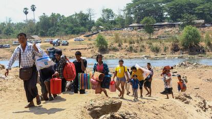 People cross the Moei river as they flee Myawaddy township in Myanmar to Thailand's Mae Sot town in Thailand's Tak province, Saturday, April 20, 2024