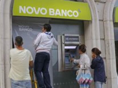 Trabajadores instalan el nuevo logo de Novo Banco en una oficina de Lisboa.