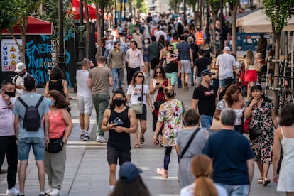 Decenas de personas, la mayoria con mascarilla, caminando hoy por la calle Montera, Madrid.