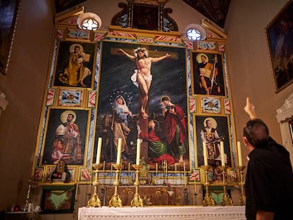El sacerdote Antonio Fajardo explica el retablo en la iglesia de San Miguel de Guadix (Granada).