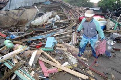 Un superviviente del <i>tsunami</i> inspecciona las ruinas de su casa.