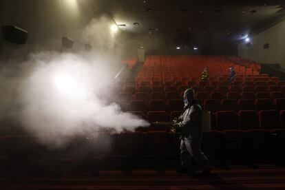 Un voluntario desinfecta la sala de un teatro antes de su reapertura, en Pekín (China).