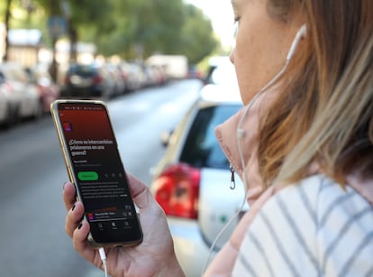 Una persona escucha un 'podcast' de EL PAÍS en una calle madrileña.