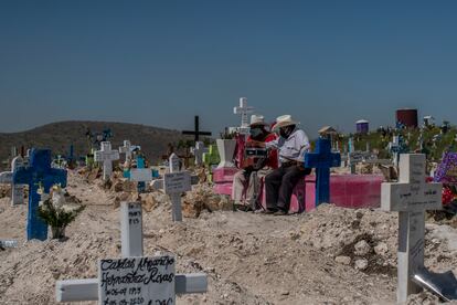 Dos músicos esperan por funerales en la nueva zona del panteón numero 12 de Tijuana.