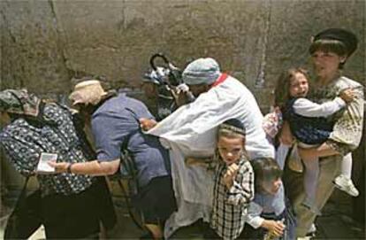 Mujeres y niños judíos corren a refugiarse en el momento en que los palestinos comenzaron a lanzar piedras sobre el Muro.