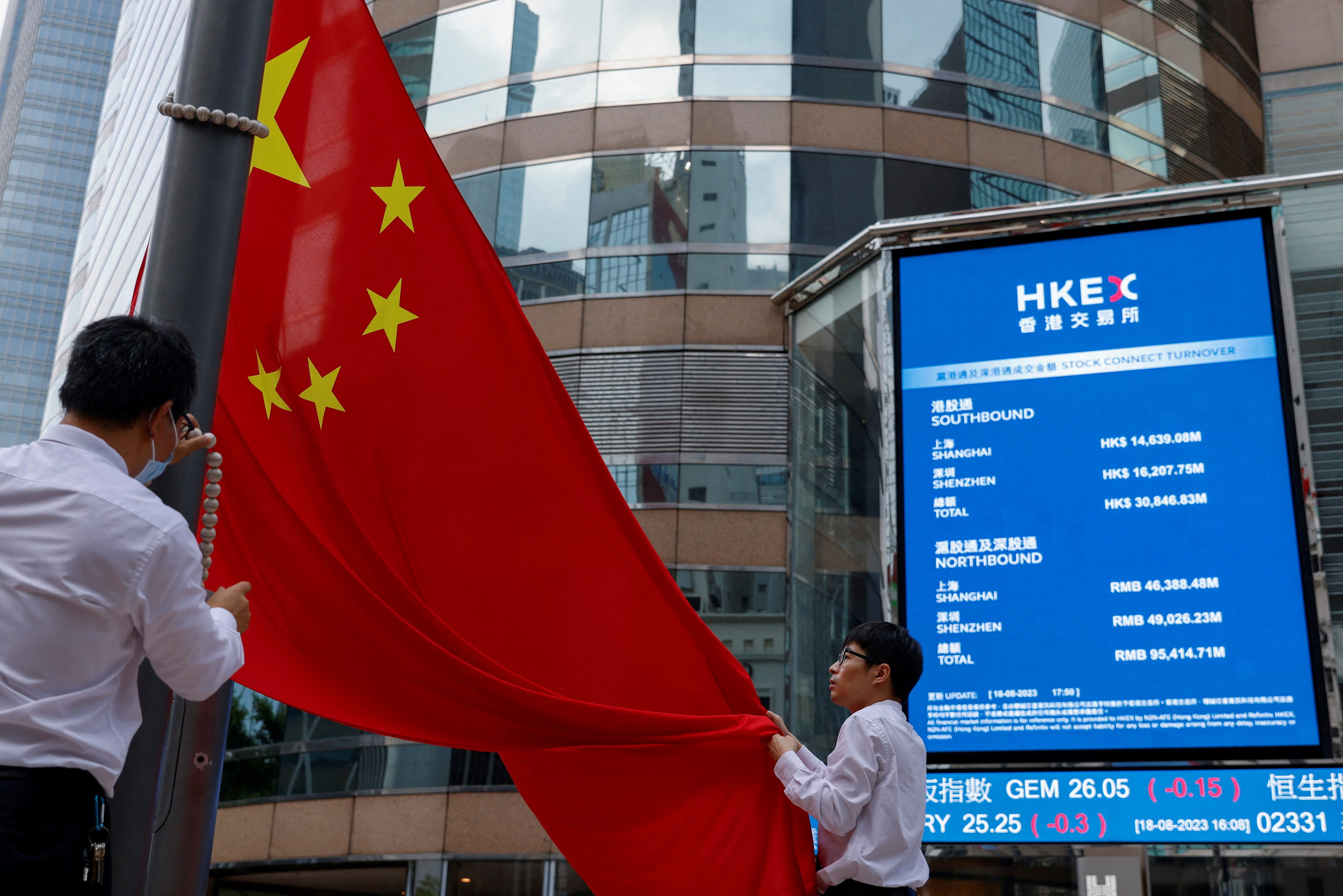 Trabajadores de la Bolsa de Hong Kong arrían la bandera de China.