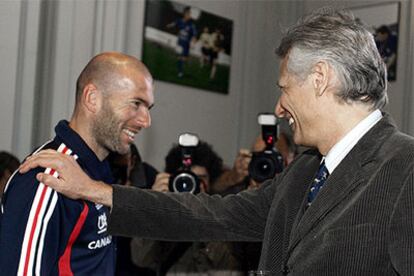 Zinedine Zidane, saludado por el primer ministro francés, Villepin, puede seguir jugando al fútbol tras el Mundial.