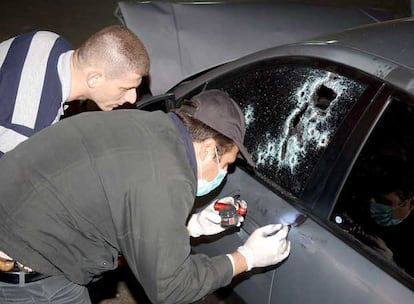 Miembros de las fuerzas de seguridad investigan el coche en el que viajaba el ministro de Industria libans.