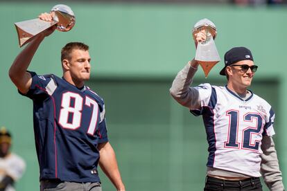Rob Gronkowski y Tom Brady enseñan dos de sus trofeos de la Super Bowl, en 2017.