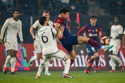 El delantero polaco del FC Barcelona Robert Lewandowski  disputa un balón ante Nacho, defensa del Real Madrid.
